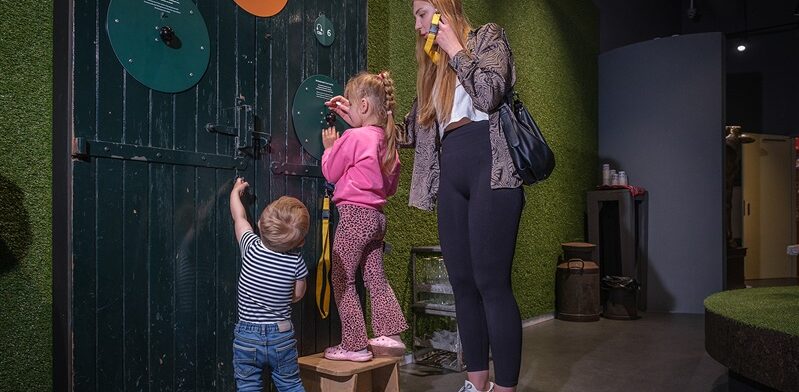 Kinderen ontdekken interactieve elementen in de Gouda Cheese Experience, samen met een ouder.