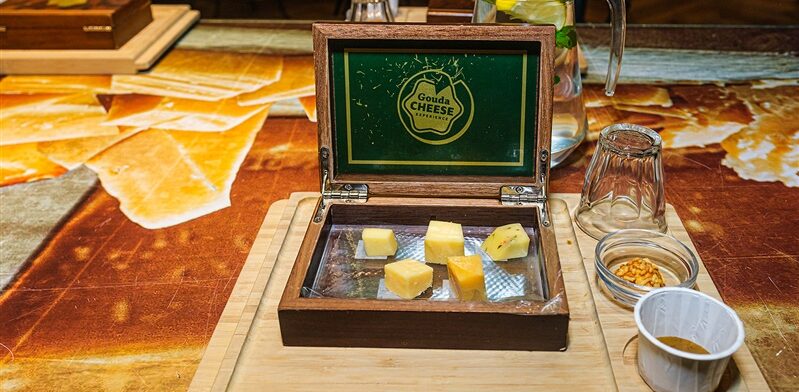 Proeverij bij de Gouda Cheese Experience met verschillende stukjes Goudse kaas, noten en honing.
