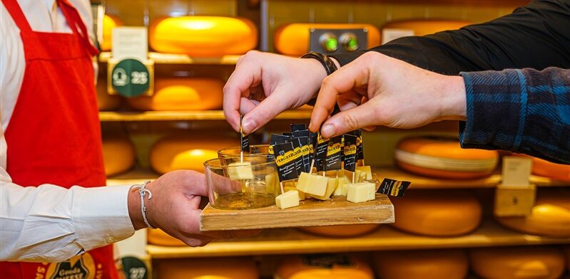 Bezoekers proeven samen stukjes Goudse kaas tijdens een kaasproeverij in de Gouda Cheese Experience.