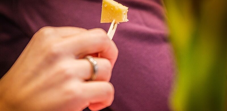 Bezoeker van de Gouda Cheese Experience proeft een stukje oude Goudse kaas voor de echte umami-beleving.